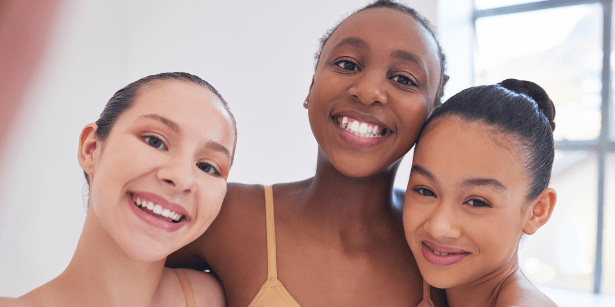 Three teenage girls take a selfie at dance class