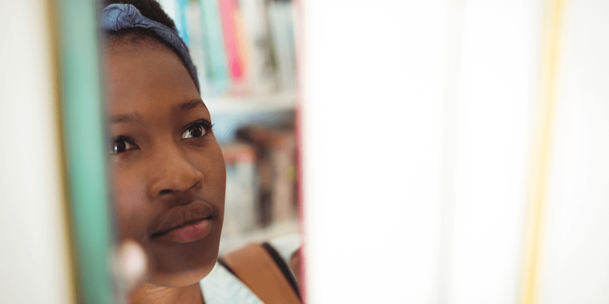 Teenage girl looks between books
