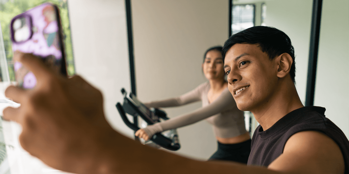 A young man and a young woman take a gym selfie