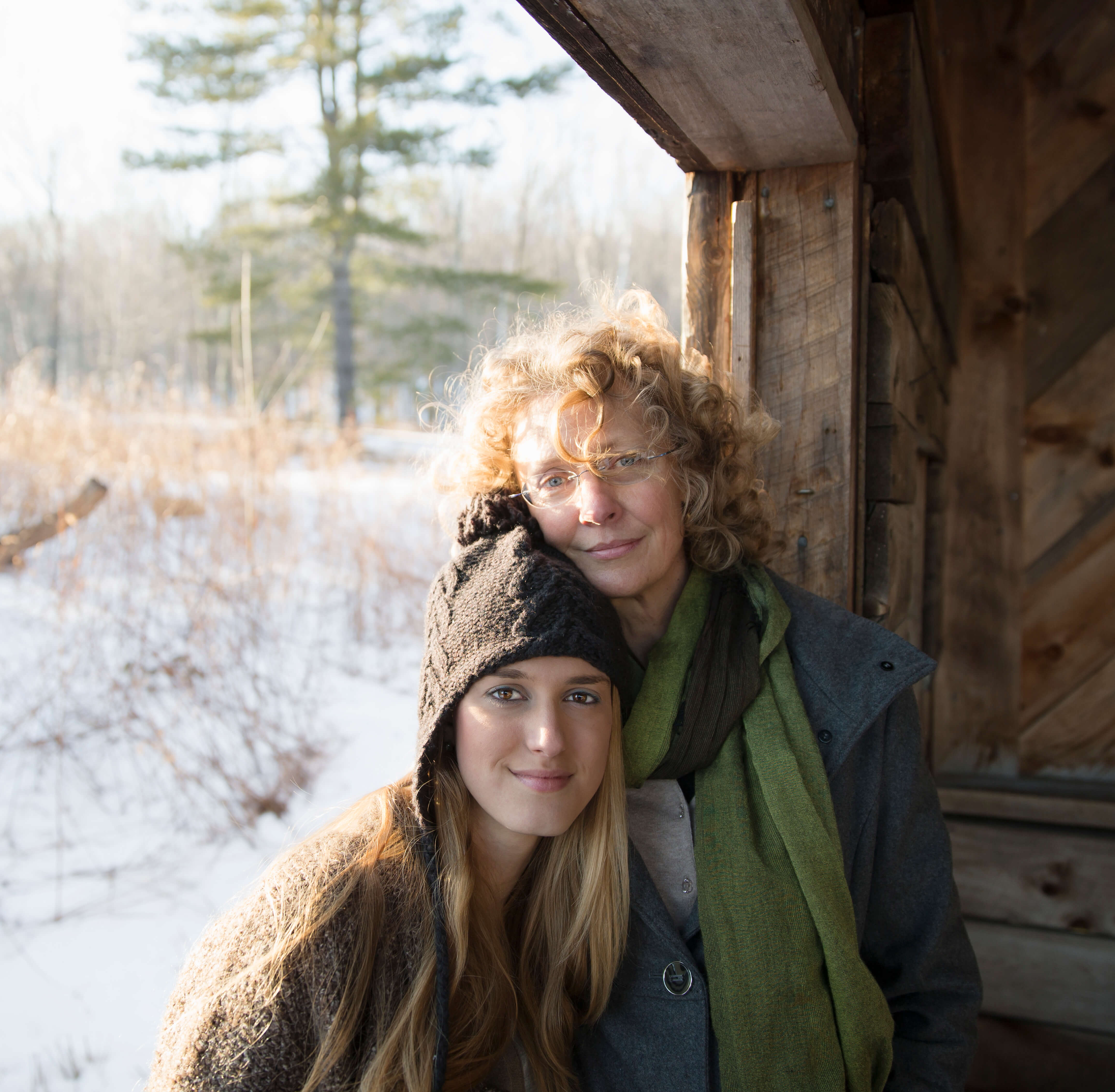 A mother and daughter sitting together on a porch