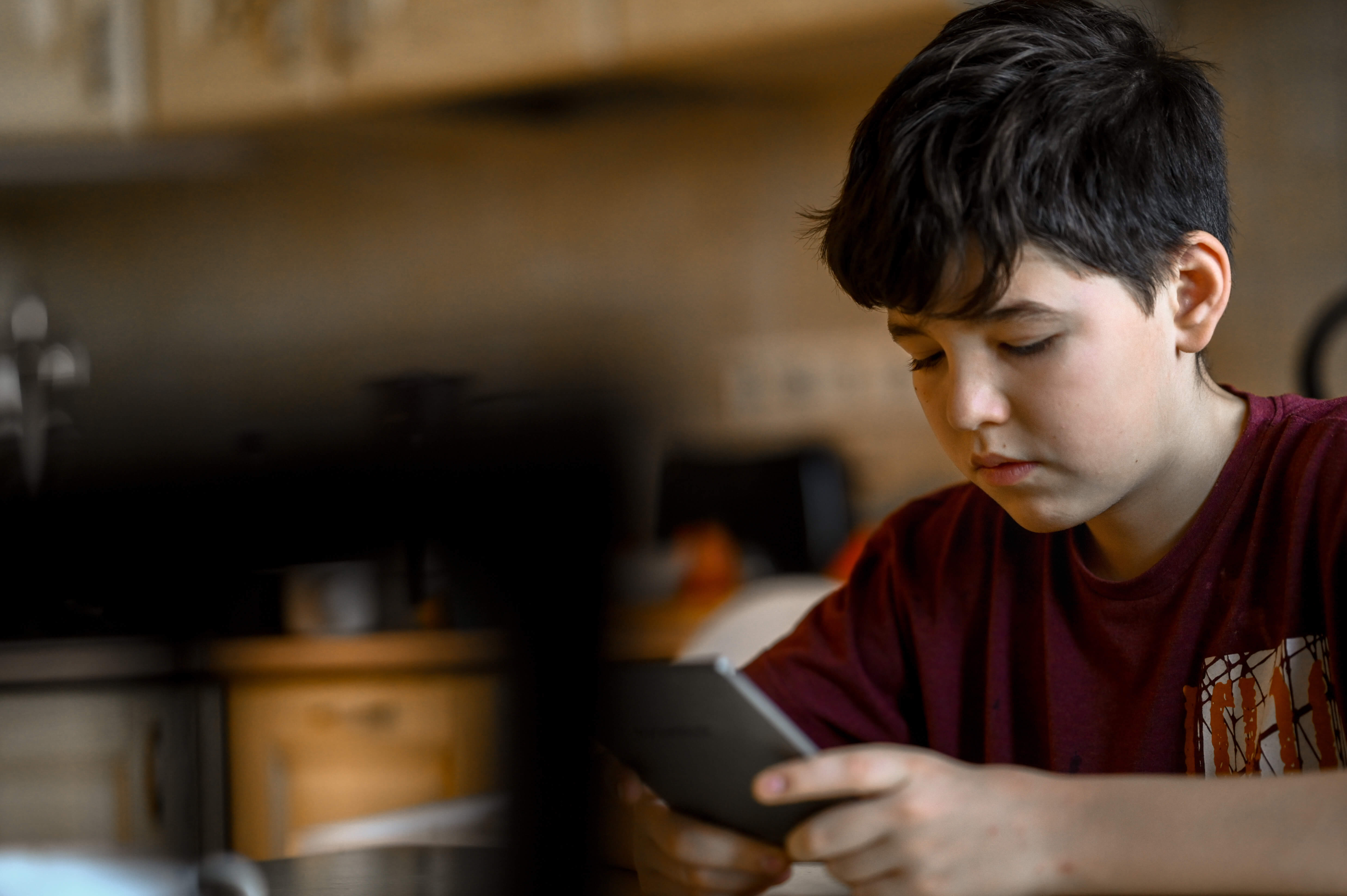 Boy focused on a tablet at home